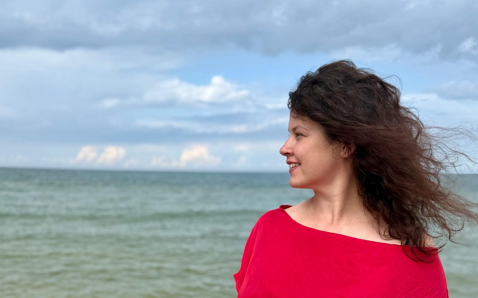 Karolina Kurpińska w czerwonej sukience nad morzem